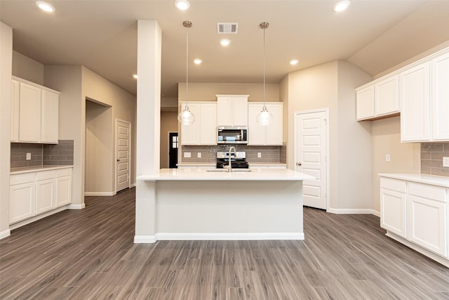 kitchen with dark wood-type flooring, sink, white cabinetry, pendant lighting, and stainless steel appliances