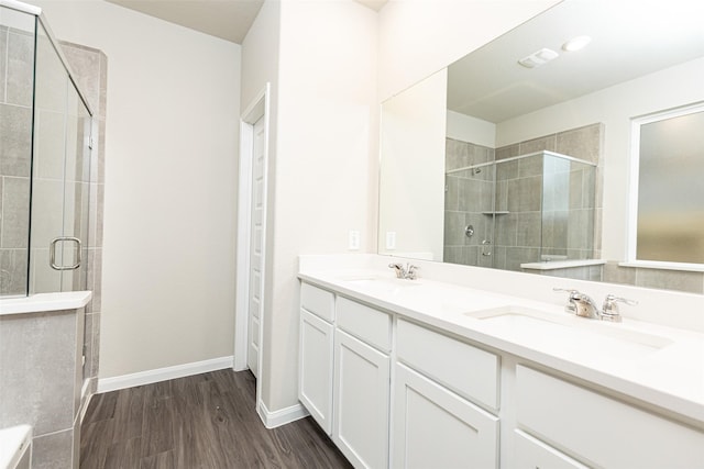 bathroom featuring vanity, wood-type flooring, and a shower with shower door