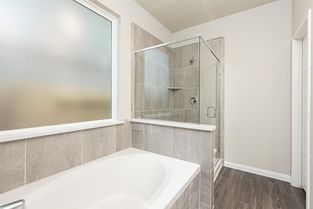 bathroom with hardwood / wood-style flooring and shower with separate bathtub