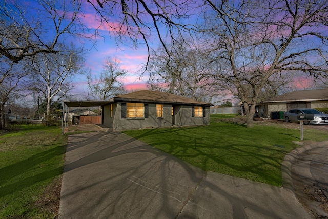 view of front of home featuring driveway, an attached carport, and a front yard