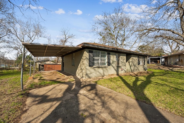 view of side of property with a carport, driveway, and a lawn