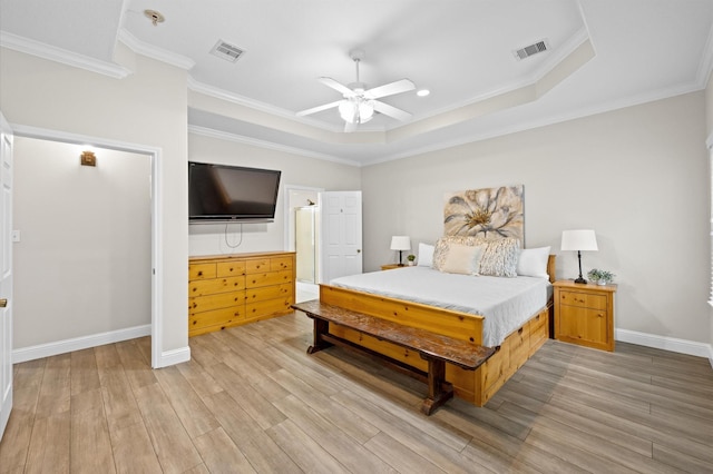 bedroom with a raised ceiling, ornamental molding, and light wood-type flooring