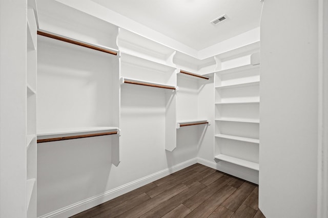 spacious closet featuring dark hardwood / wood-style flooring