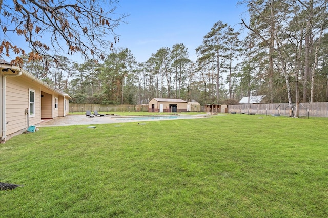 view of yard featuring a fenced in pool, a patio area, and a storage shed