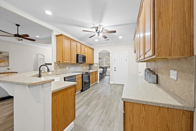 kitchen featuring sink, a breakfast bar area, ceiling fan, kitchen peninsula, and electric stove