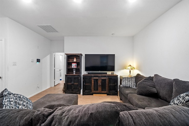 living room featuring vaulted ceiling and light hardwood / wood-style floors