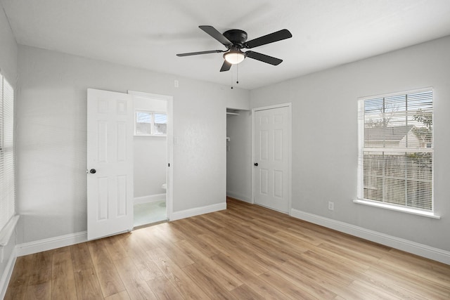 unfurnished bedroom with a closet, ensuite bathroom, ceiling fan, and light wood-type flooring