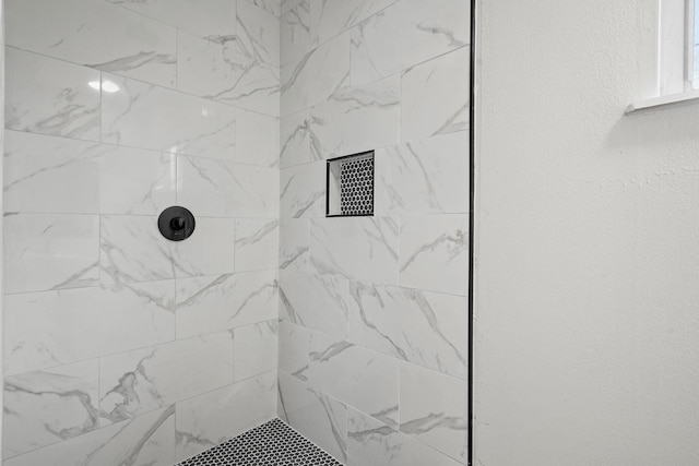 interior details with a tile shower