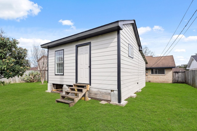 rear view of property featuring a lawn