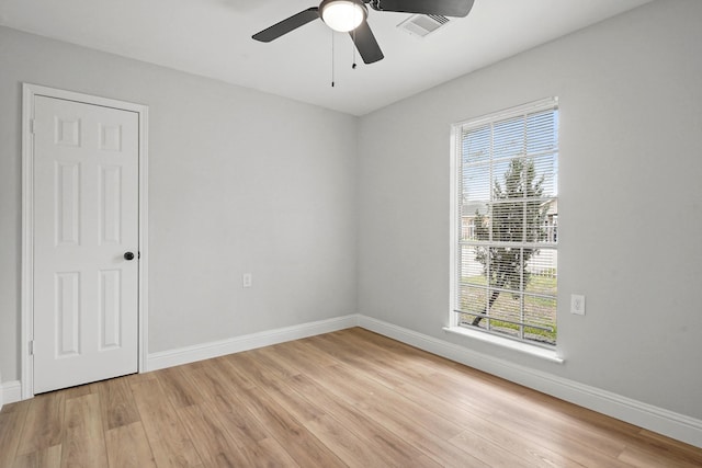 empty room with ceiling fan and light hardwood / wood-style flooring