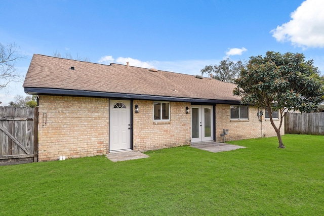 rear view of property with french doors and a lawn