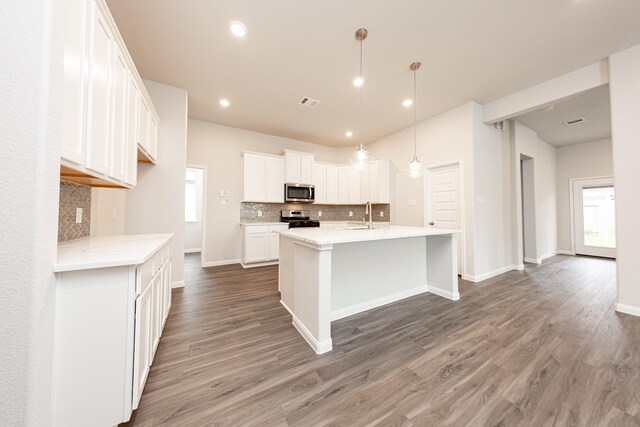 3013 Plains Cir, Brookshire, TX 77423 - kitchen featuring light wood-style flooring, an island with sink, a sink, appliances with stainless steel finishes, and white cabinetry