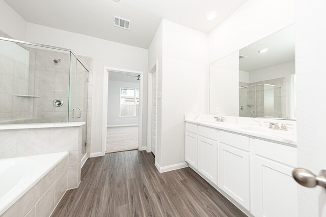 3013 Plains Cir, Brookshire, TX 77423 - bathroom featuring a bath, wood finished floors, visible vents, and a stall shower