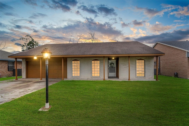 ranch-style home with a garage, a yard, and covered porch