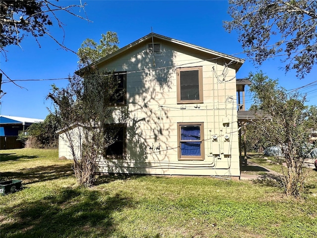 back of house with a lawn