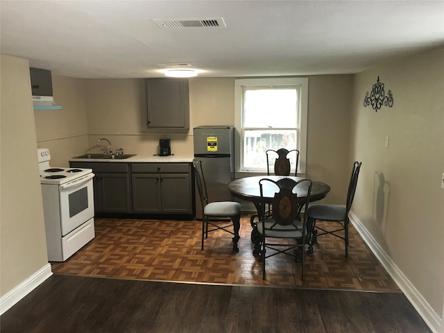 kitchen featuring gray cabinets, sink, electric range, and stainless steel refrigerator