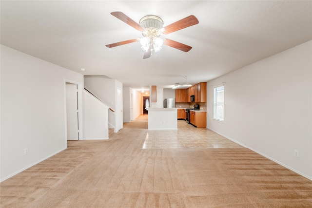 unfurnished living room with ceiling fan and light colored carpet