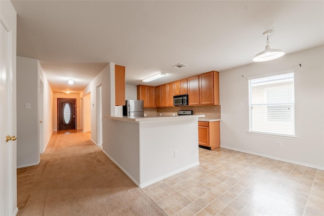 kitchen with stainless steel refrigerator, tasteful backsplash, hanging light fixtures, light colored carpet, and kitchen peninsula