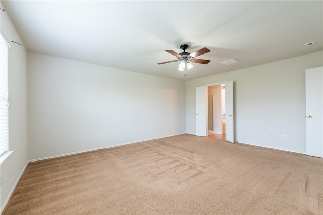 spare room featuring light colored carpet and ceiling fan