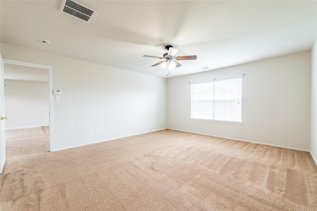 spare room featuring light carpet and ceiling fan