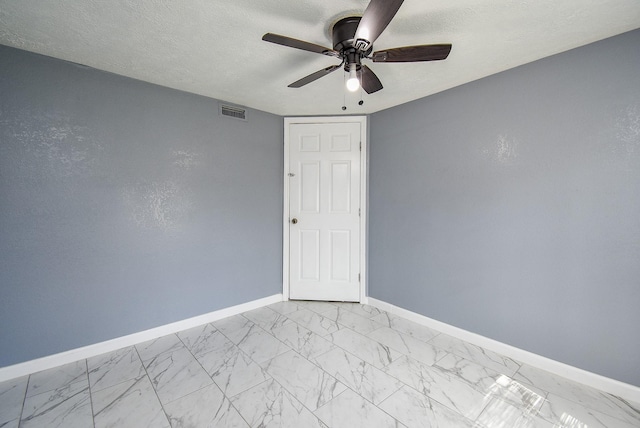 spare room with ceiling fan and a textured ceiling