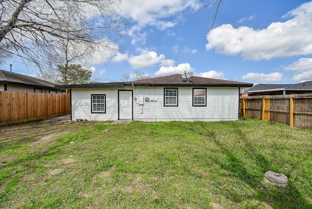 rear view of property with a lawn