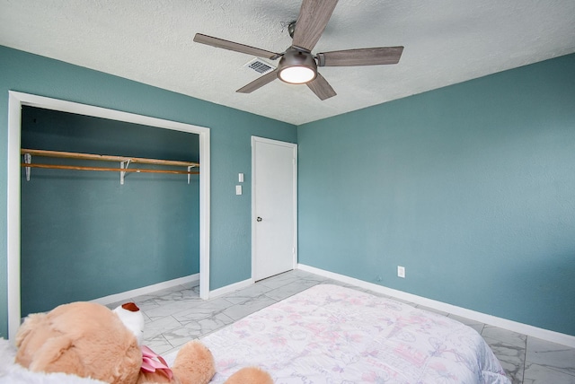 bedroom featuring ceiling fan, a closet, and a textured ceiling