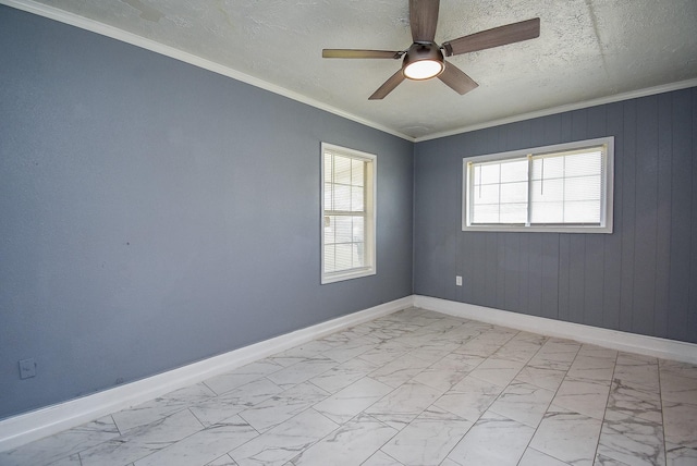 spare room with a textured ceiling, ornamental molding, and ceiling fan