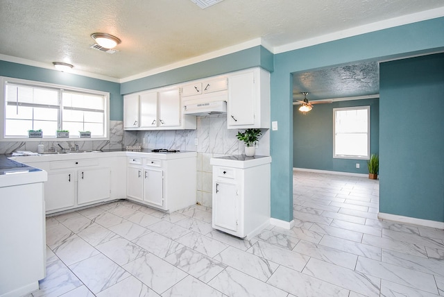 kitchen featuring ceiling fan, decorative backsplash, a textured ceiling, and white cabinets