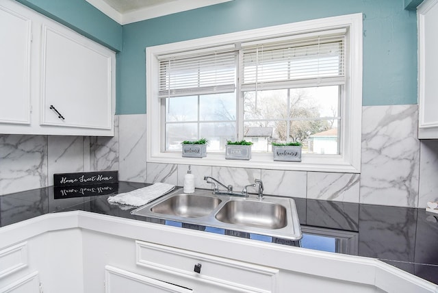 kitchen featuring sink, decorative backsplash, and white cabinets