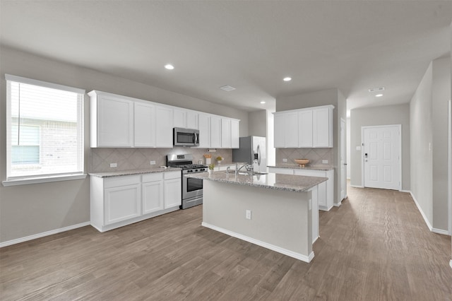 kitchen with white cabinetry, stainless steel appliances, and light wood-type flooring