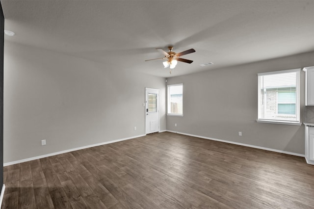 empty room with dark hardwood / wood-style floors and ceiling fan