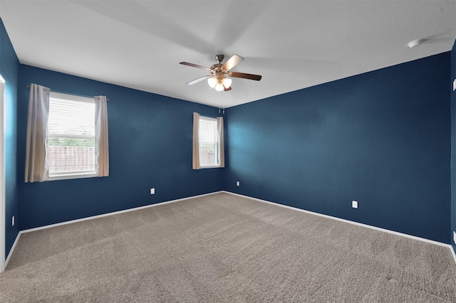 carpeted spare room featuring ceiling fan