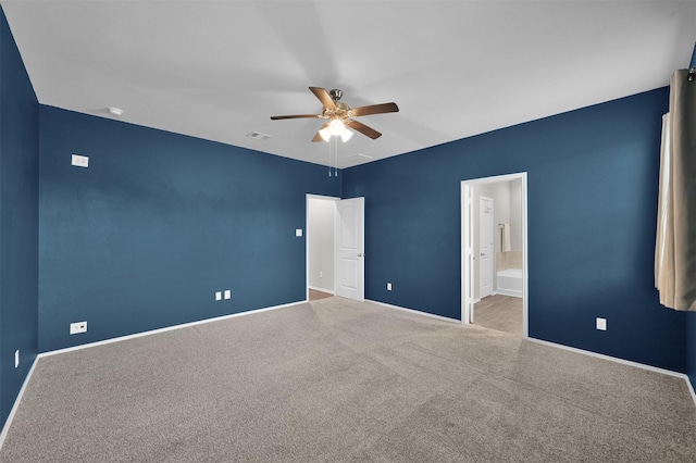 unfurnished bedroom with ceiling fan, light colored carpet, and ensuite bath