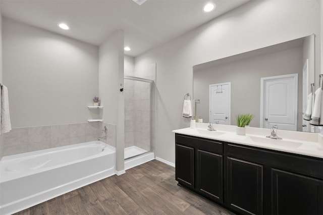 bathroom with hardwood / wood-style flooring, vanity, and plus walk in shower