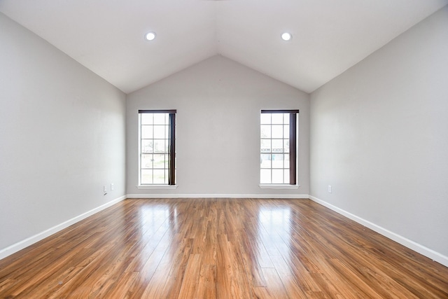 spare room with lofted ceiling and hardwood / wood-style floors