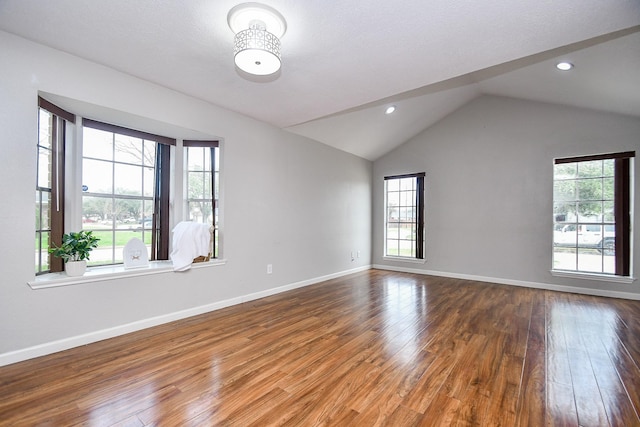 empty room featuring vaulted ceiling and hardwood / wood-style floors