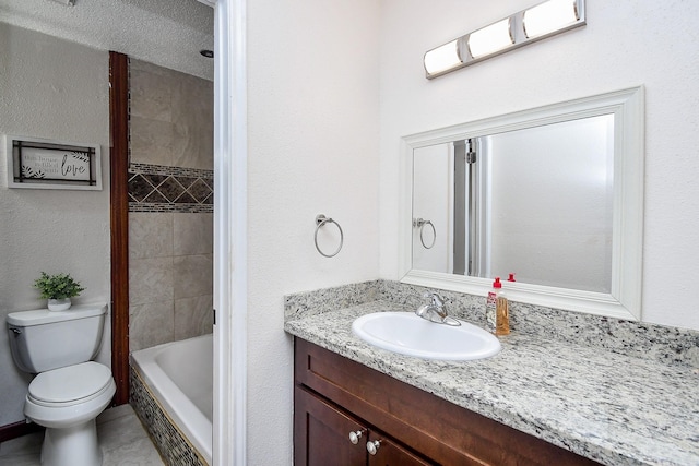 full bathroom featuring tiled shower / bath combo, vanity, and toilet