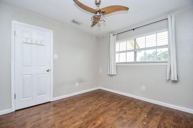 unfurnished room featuring ceiling fan, a textured ceiling, and dark hardwood / wood-style flooring