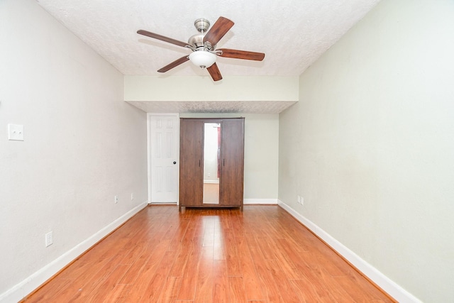 unfurnished bedroom with ceiling fan, light hardwood / wood-style flooring, and a textured ceiling