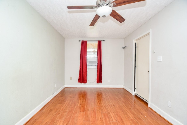 spare room featuring ceiling fan, light hardwood / wood-style floors, and a textured ceiling