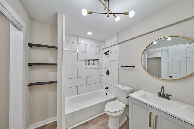 full bathroom with tiled shower / bath, hardwood / wood-style floors, vanity, and toilet