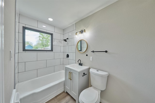 full bathroom with vanity, tiled shower / bath combo, toilet, and hardwood / wood-style flooring