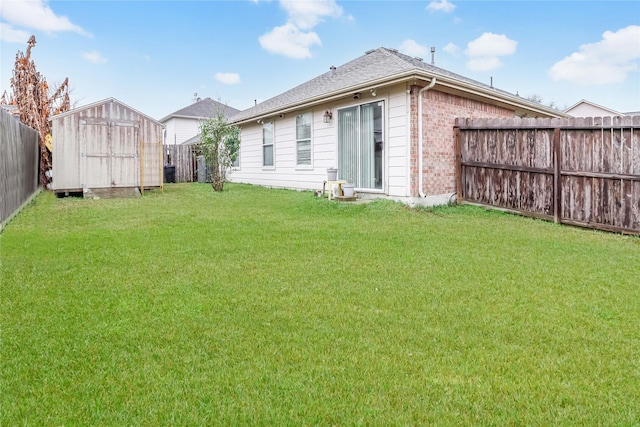 rear view of property featuring a lawn and a storage unit