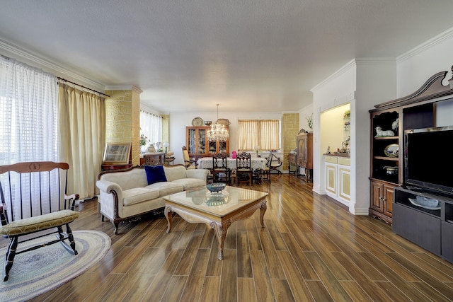 living room featuring crown molding, dark hardwood / wood-style floors, a notable chandelier, and a textured ceiling