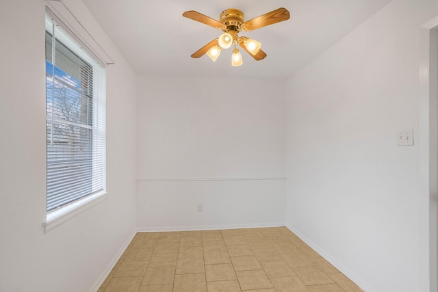 empty room with ceiling fan and light tile patterned floors