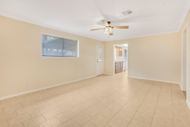 empty room with light tile patterned floors, a textured ceiling, ornamental molding, and ceiling fan