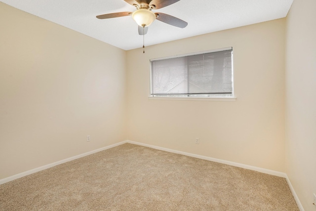 spare room with ceiling fan and carpet