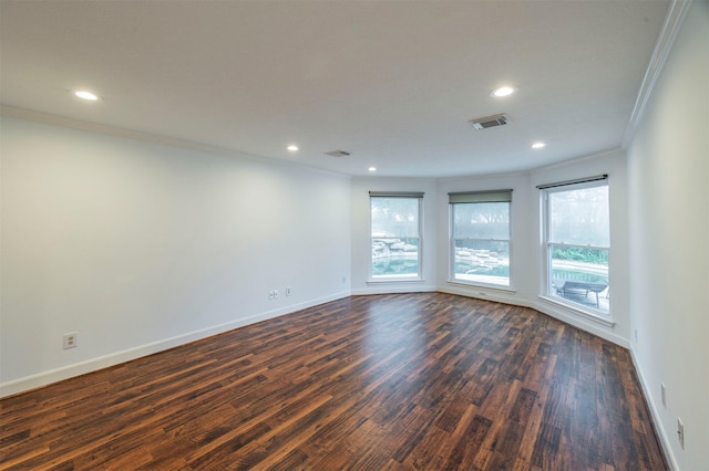 spare room with baseboards, crown molding, visible vents, and dark wood-style flooring