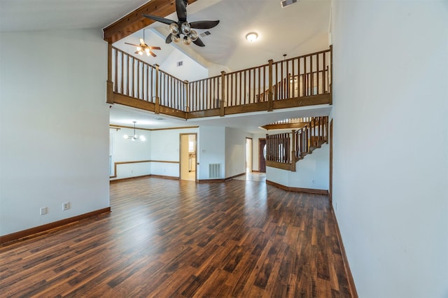 unfurnished living room with dark wood-style floors, visible vents, stairway, high vaulted ceiling, and baseboards